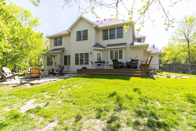 back of house with a deck, a patio area, a fire pit, and a shingled roof