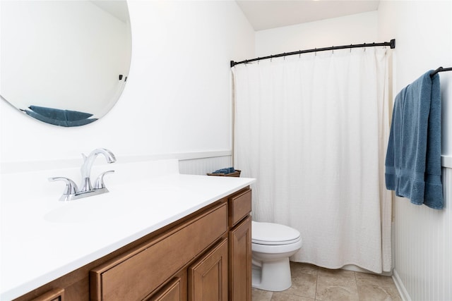 bathroom featuring toilet, tile patterned floors, vanity, and curtained shower
