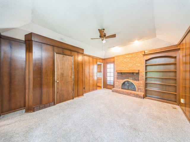 3800 Western Hills Dr, West Des Moines, IA 50265 - unfurnished living room with ceiling fan, built in shelves, carpet flooring, a fireplace, and a textured ceiling