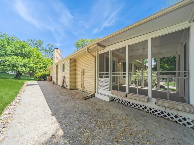 3800 Western Hills Dr, West Des Moines, IA 50265 - view of side of home featuring a sunroom and a chimney