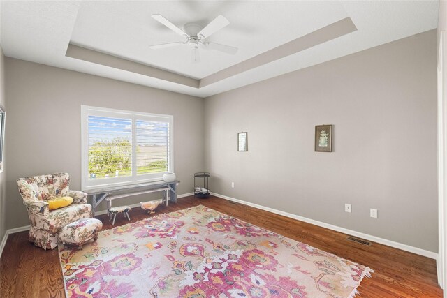 4400 132nd St, Urbandale, IA 50323 - sitting room featuring a raised ceiling, wood finished floors, baseboards, and ceiling fan