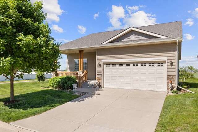 4400 132nd St, Urbandale, IA 50323 - view of front of home with a front yard, stone siding, an attached garage, and driveway