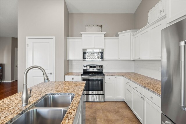 4400 132nd St, Urbandale, IA 50323 - kitchen with stainless steel appliances, a sink, tasteful backsplash, and white cabinetry