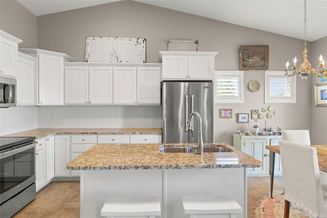 4400 132nd St, Urbandale, IA 50323 - kitchen with stainless steel appliances, a sink, vaulted ceiling, white cabinetry, and light stone counters