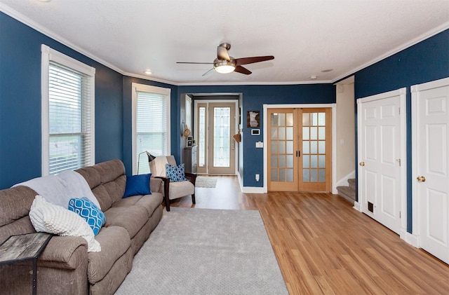 1807 11th St, Des Moines, IA 50314 - living room featuring french doors, crown molding, light wood-style flooring, ceiling fan, and baseboards