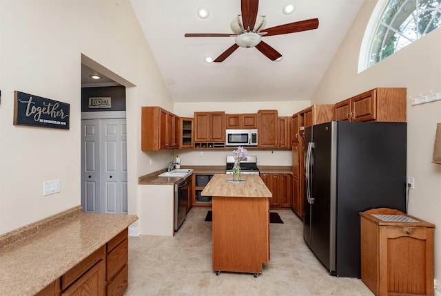 1807 11th St, Des Moines, IA 50314 - kitchen featuring appliances with stainless steel finishes, ceiling fan, wooden counters, a sink, and a kitchen island