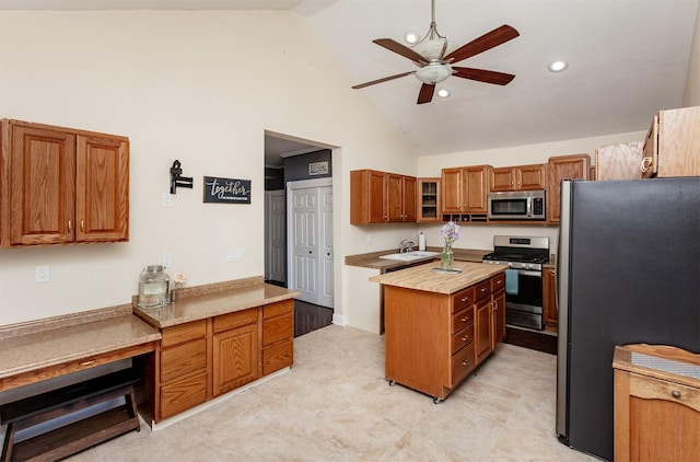 1807 11th St, Des Moines, IA 50314 - kitchen featuring stainless steel appliances, a ceiling fan, high vaulted ceiling, brown cabinetry, and a center island