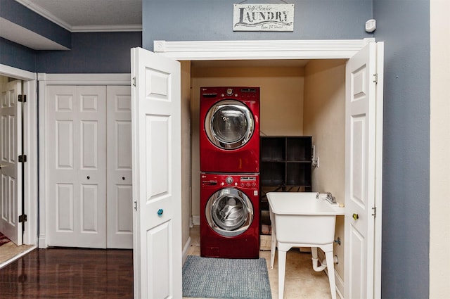 1807 11th St, Des Moines, IA 50314 - laundry area featuring estacked washer and dryer, crown molding, and baseboards