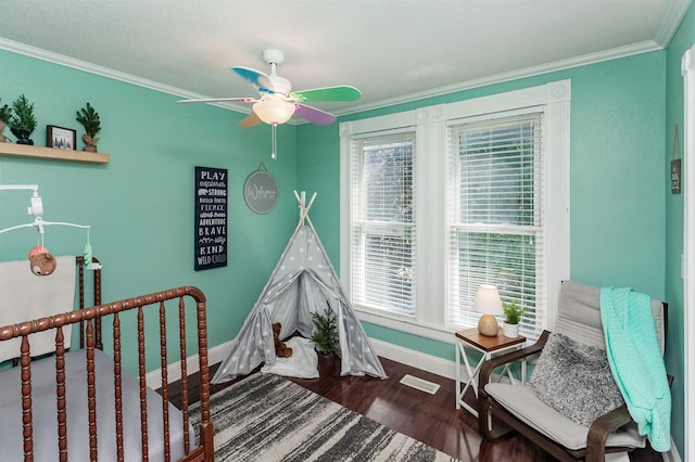 1807 11th St, Des Moines, IA 50314 - bedroom featuring baseboards, wood finished floors, crown molding, and ceiling fan
