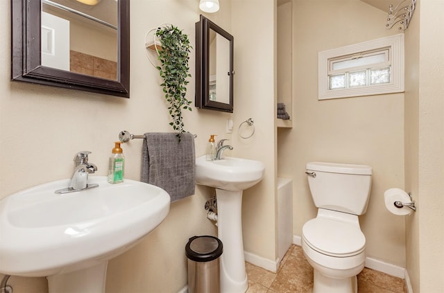 1807 11th St, Des Moines, IA 50314 - bathroom featuring toilet, a sink, and tile patterned floors