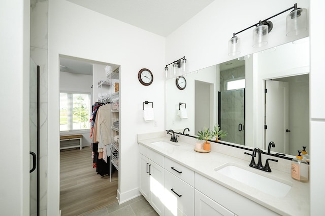 16427 N Valley Dr, Urbandale, IA 50323 - bathroom featuring double vanity, a stall shower, and a spacious closet