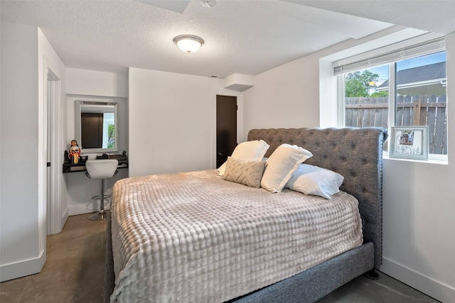 208 Mckinley Ave, Des Moines, IA 50315 - bedroom with baseboards, concrete flooring, and a textured ceiling