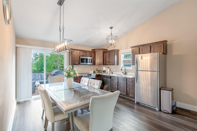 208 Mckinley Ave, Des Moines, IA 50315 - dining area featuring a chandelier, dark wood-style flooring, lofted ceiling, and baseboards