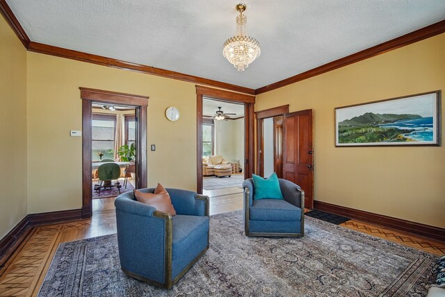 311 E Main St, Panora, IA 50216 - living area with crown molding, a chandelier, baseboards, a textured ceiling, and wood finished floors