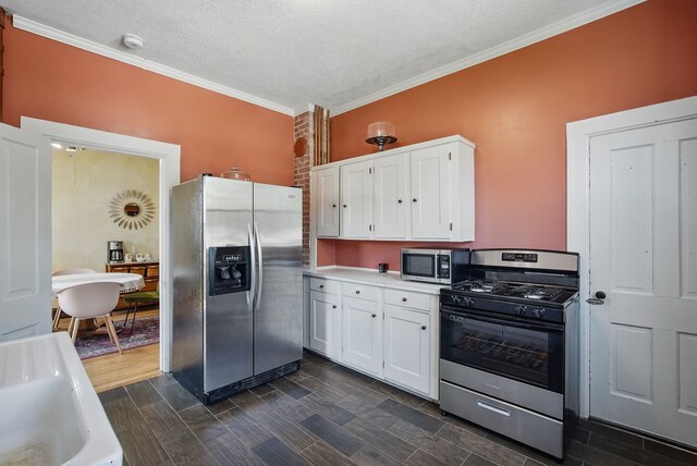 311 E Main St, Panora, IA 50216 - kitchen with appliances with stainless steel finishes, white cabinetry, crown molding, light countertops, and a textured ceiling