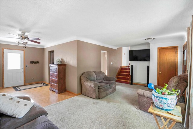 2106 62nd St, Des Moines, IA 50322 - living room featuring stairs, baseboards, a ceiling fan, and light wood-style floors