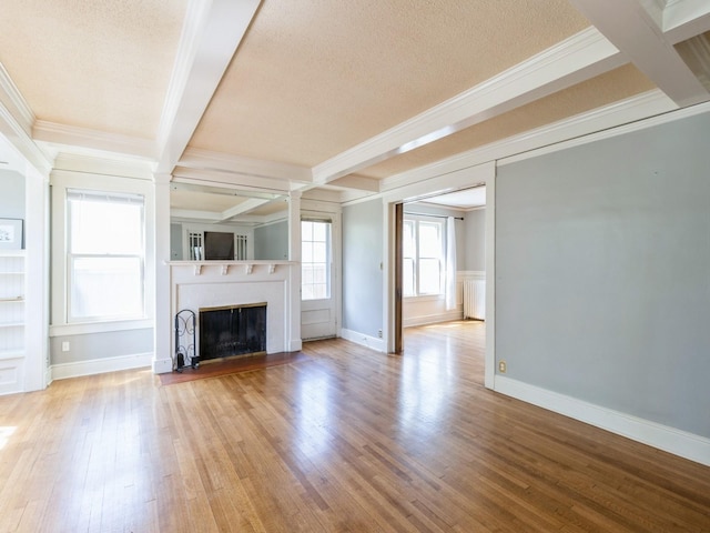 1070 37th St, Des Moines, IA 50311 - unfurnished living room with ornamental molding, a textured ceiling, wood finished floors, a fireplace, and baseboards