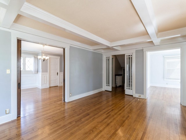 1070 37th St, Des Moines, IA 50311 - unfurnished room with crown molding, a chandelier, coffered ceiling, beam ceiling, and radiator heating unit