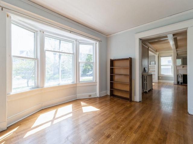 1070 37th St, Des Moines, IA 50311 - unfurnished living room with wood finished floors, healthy amount of natural light, baseboards, and ornamental molding