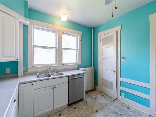 1070 37th St, Des Moines, IA 50311 - kitchen featuring radiator heating unit, dishwasher, a sink, and white cabinetry