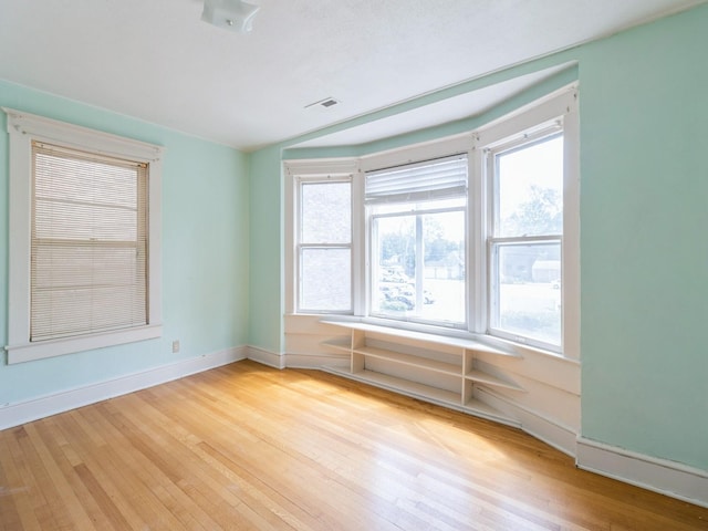 1070 37th St, Des Moines, IA 50311 - empty room with wood finished floors, healthy amount of natural light, and baseboards