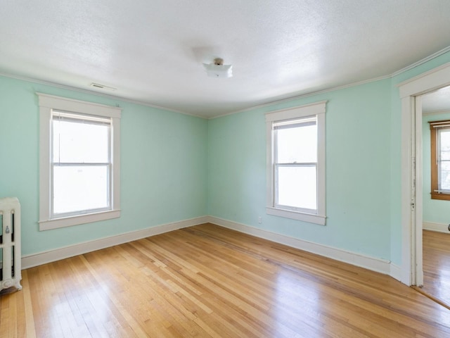 1070 37th St, Des Moines, IA 50311 - empty room featuring light wood-style flooring, baseboards, and ornamental molding