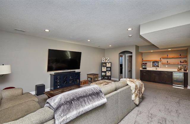 1412 NE Aspen Ct, Grimes, IA 50111 - living room featuring wine cooler, bar with sink, recessed lighting, carpet, and arched walkways