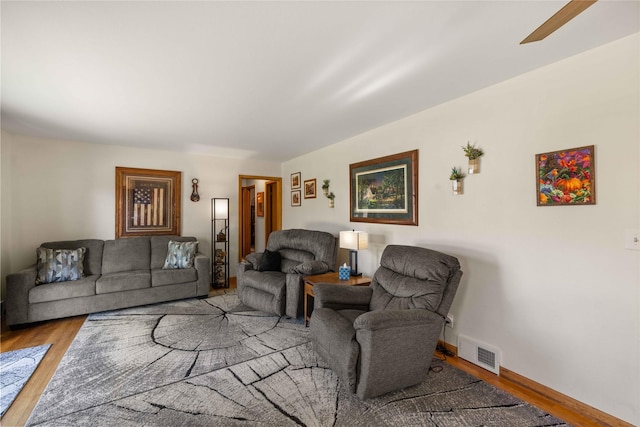 living room with wood finished floors, baseboards, and a ceiling fan