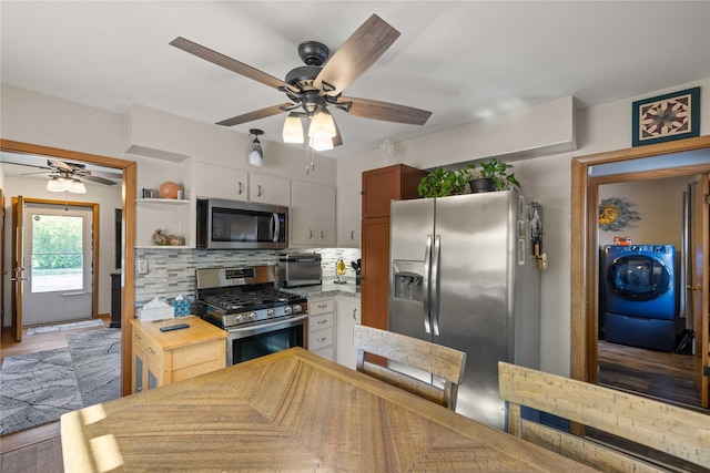 kitchen with appliances with stainless steel finishes, washer / clothes dryer, a ceiling fan, tasteful backsplash, and light countertops