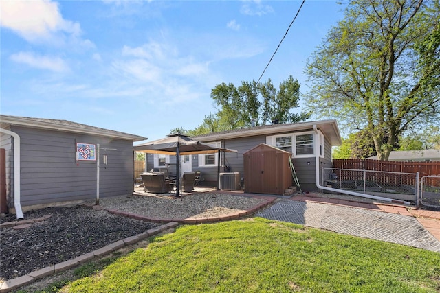 back of house featuring an outdoor structure, a patio area, and a storage unit