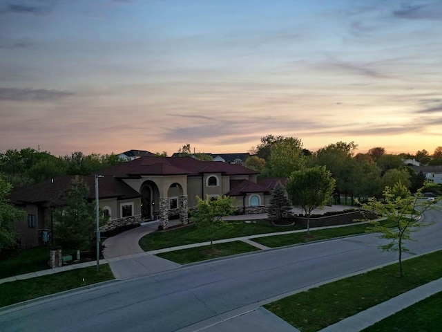 4408 Cochrane Pkwy, Ames, IA 50014 - mediterranean / spanish house featuring a front yard, stucco siding, and curved driveway
