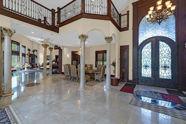 4408 Cochrane Pkwy, Ames, IA 50014 - foyer entrance featuring ornate columns, a high ceiling, french doors, a chandelier, and marble tiled floors