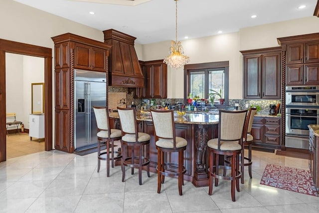 4408 Cochrane Pkwy, Ames, IA 50014 - kitchen with appliances with stainless steel finishes, a warming drawer, custom range hood, a kitchen island, and decorative backsplash