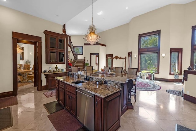 4408 Cochrane Pkwy, Ames, IA 50014 - kitchen featuring stainless steel dishwasher, a sink, baseboards, a kitchen breakfast bar, and a towering ceiling