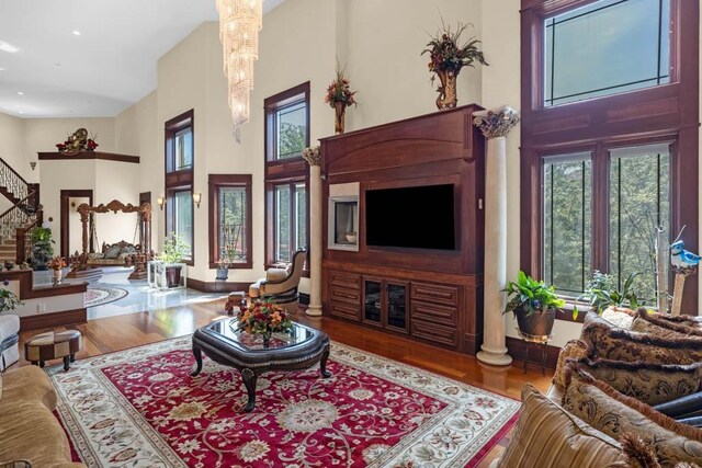 4408 Cochrane Pkwy, Ames, IA 50014 - living room featuring a towering ceiling, stairs, wood finished floors, recessed lighting, and decorative columns