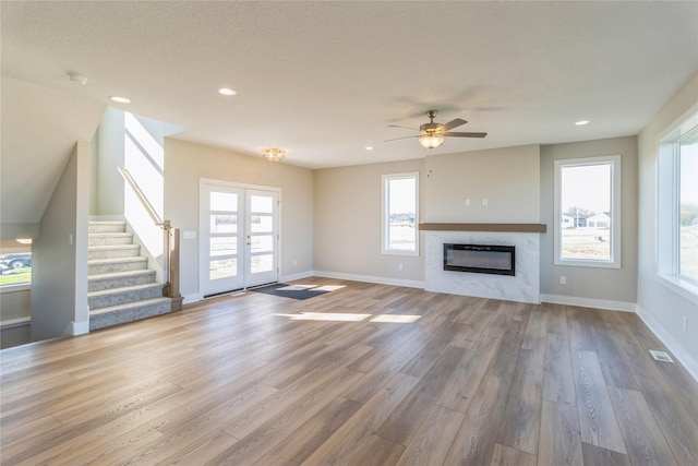 17151 Plum Dr, Urbandale, IA 50323 - unfurnished living room featuring wood finished floors, ceiling fan, stairs, recessed lighting, and healthy amount of natural light