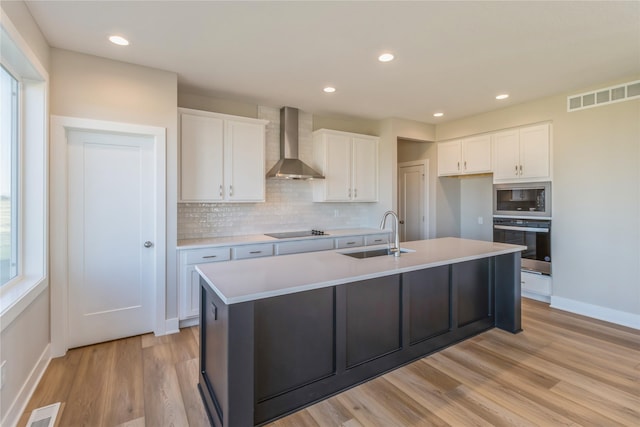 17151 Plum Dr, Urbandale, IA 50323 - kitchen with wall chimney exhaust hood, a sink, appliances with stainless steel finishes, backsplash, and white cabinetry