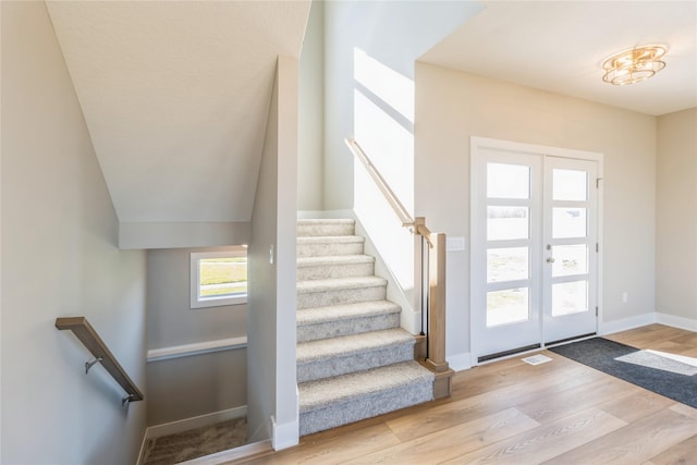 17151 Plum Dr, Urbandale, IA 50323 - stairs featuring wood finished floors, french doors, and baseboards