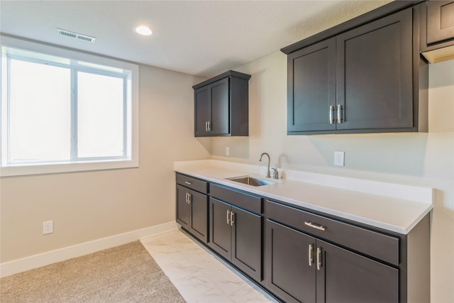 17151 Plum Dr, Urbandale, IA 50323 - kitchen with a sink, baseboards, light countertops, recessed lighting, and light marble finish flooring