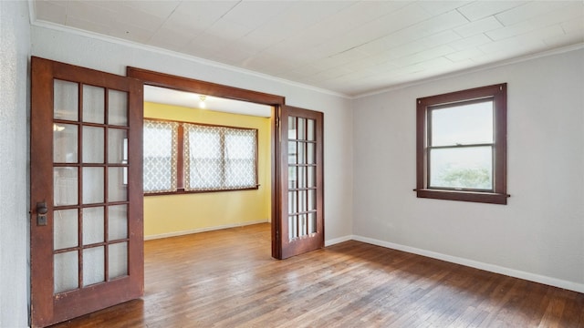 unfurnished room with crown molding, wood-type flooring, and baseboards