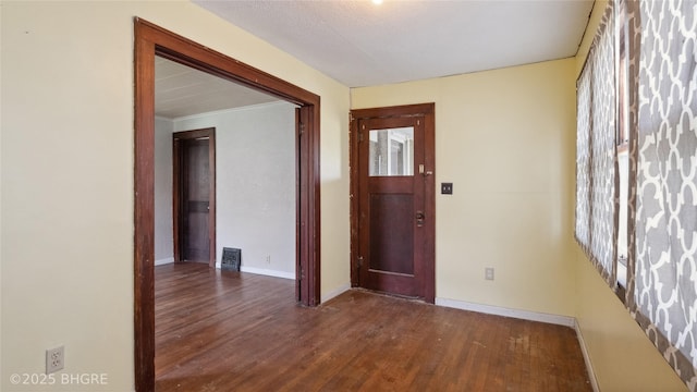 foyer entrance with wood finished floors and baseboards