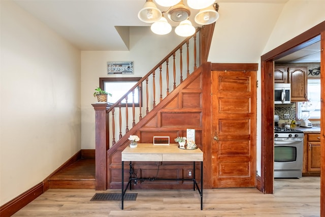 630 E Clay St, Osceola, IA 50213 - staircase with a chandelier, baseboards, and wood finished floors