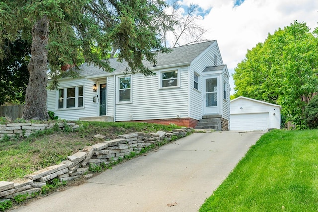 view of front of home featuring an outdoor structure, a garage, entry steps, and a shingled roof