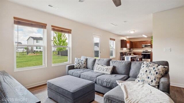 1508 E Euclid Ave, Indianola, IA 50125 - living area with baseboards, a ceiling fan, and dark wood-type flooring