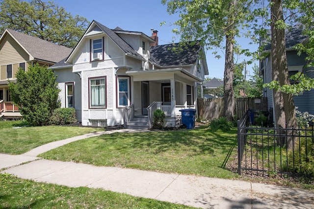 1143 27th St, Des Moines, IA 50311 - victorian house featuring stucco siding, covered porch, a chimney, and a shingled roof