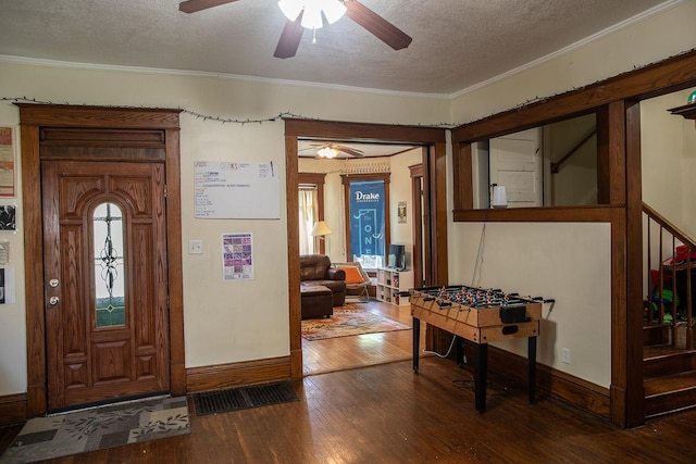 1143 27th St, Des Moines, IA 50311 - foyer entrance featuring ceiling fan, a textured ceiling, dark wood-style flooring, baseboards, and crown molding