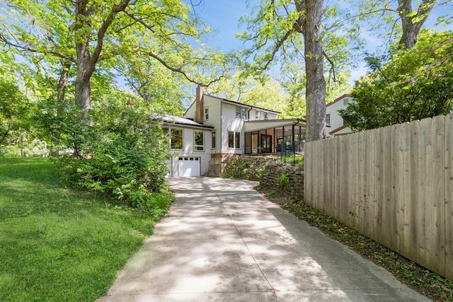 3312 Oakland St, Ames, IA 50014 - view of side of property featuring driveway, an attached garage, and a sunroom