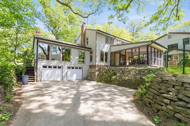 3312 Oakland St, Ames, IA 50014 - view of home's exterior featuring a sunroom, stairway, an attached garage, and a chimney
