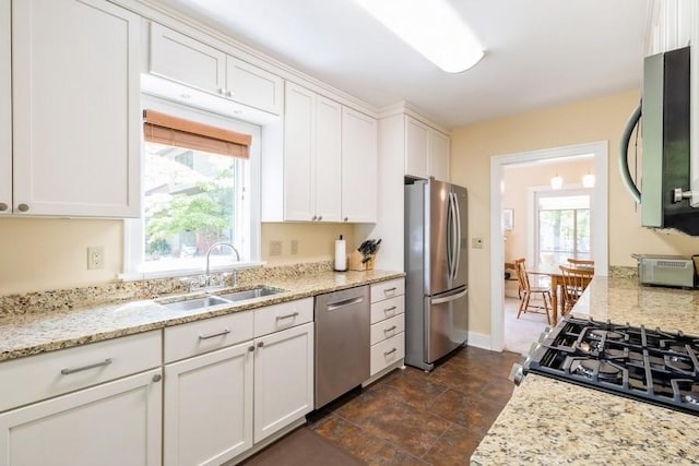 3312 Oakland St, Ames, IA 50014 - kitchen featuring appliances with stainless steel finishes, a sink, white cabinets, and light stone counters
