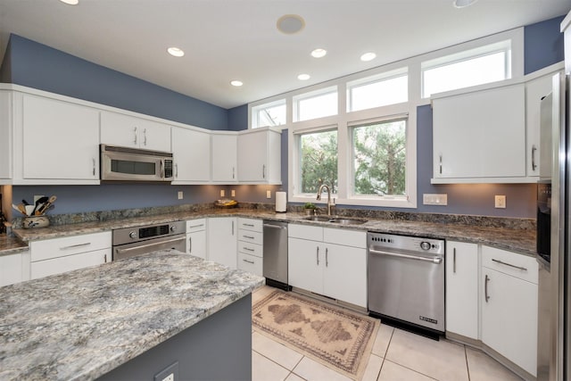 14943 Holcomb Ave, Clive, IA 50325 - kitchen featuring appliances with stainless steel finishes, white cabinets, recessed lighting, light tile patterned flooring, and dark stone countertops